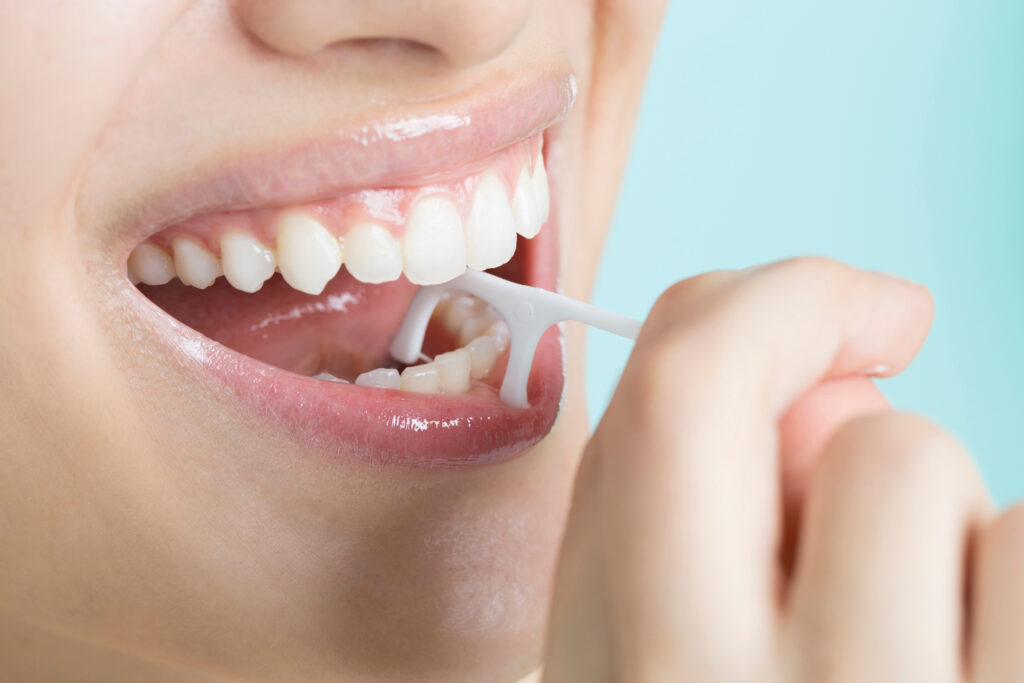 歯間ブラシで清掃する女性の口元