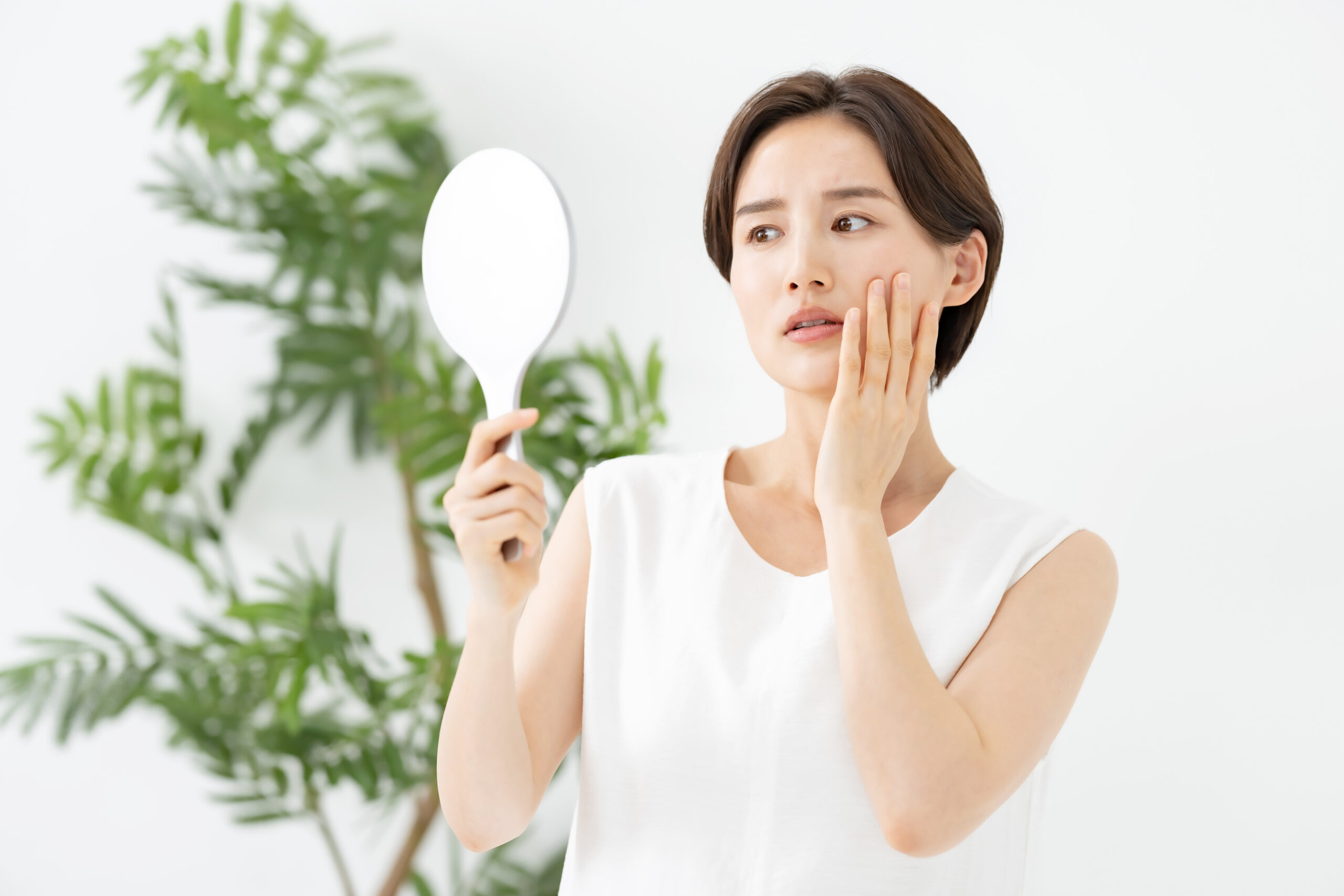 鏡を持って歯をチェックする女性