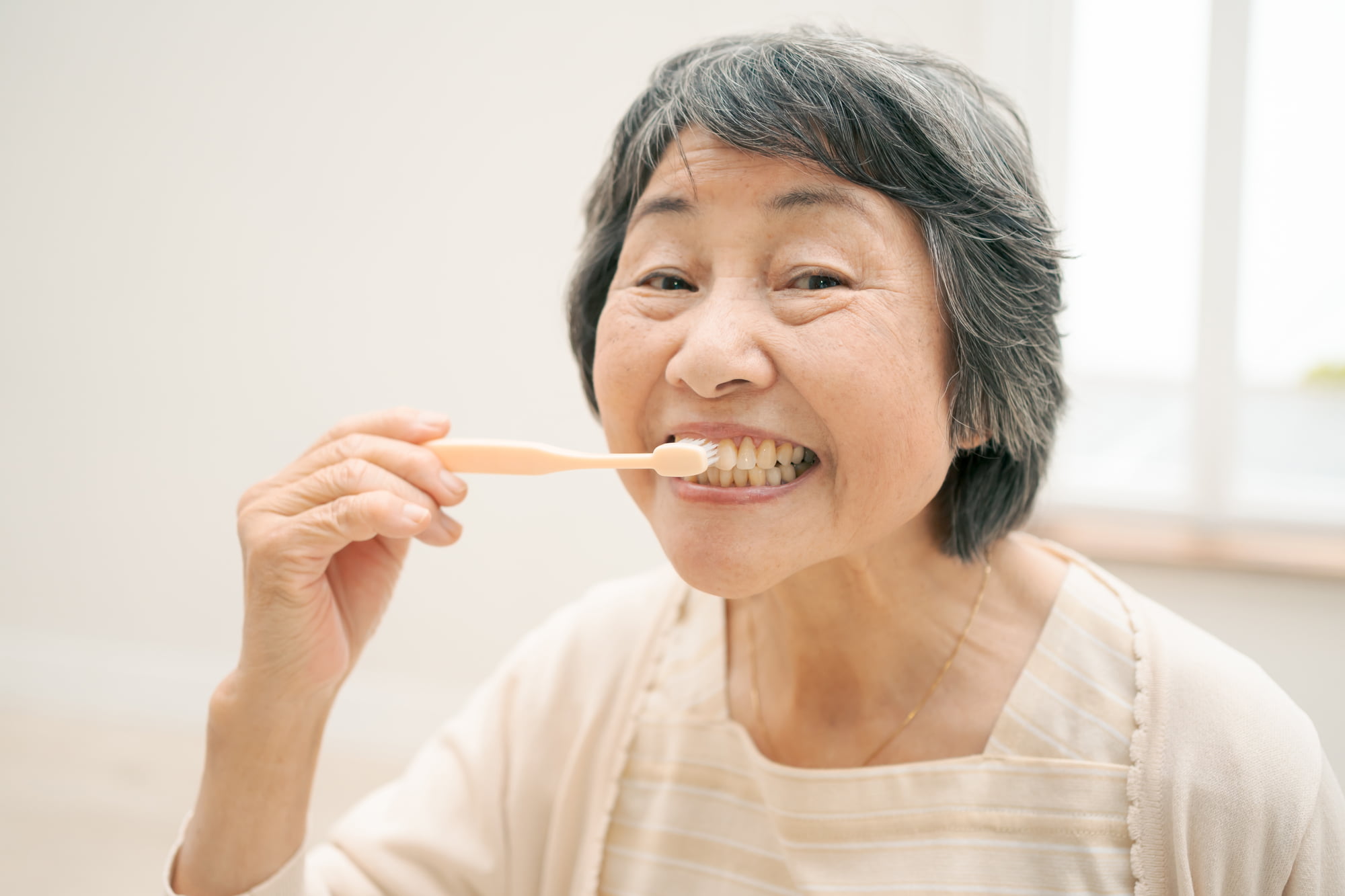 歯磨きをする高齢女性