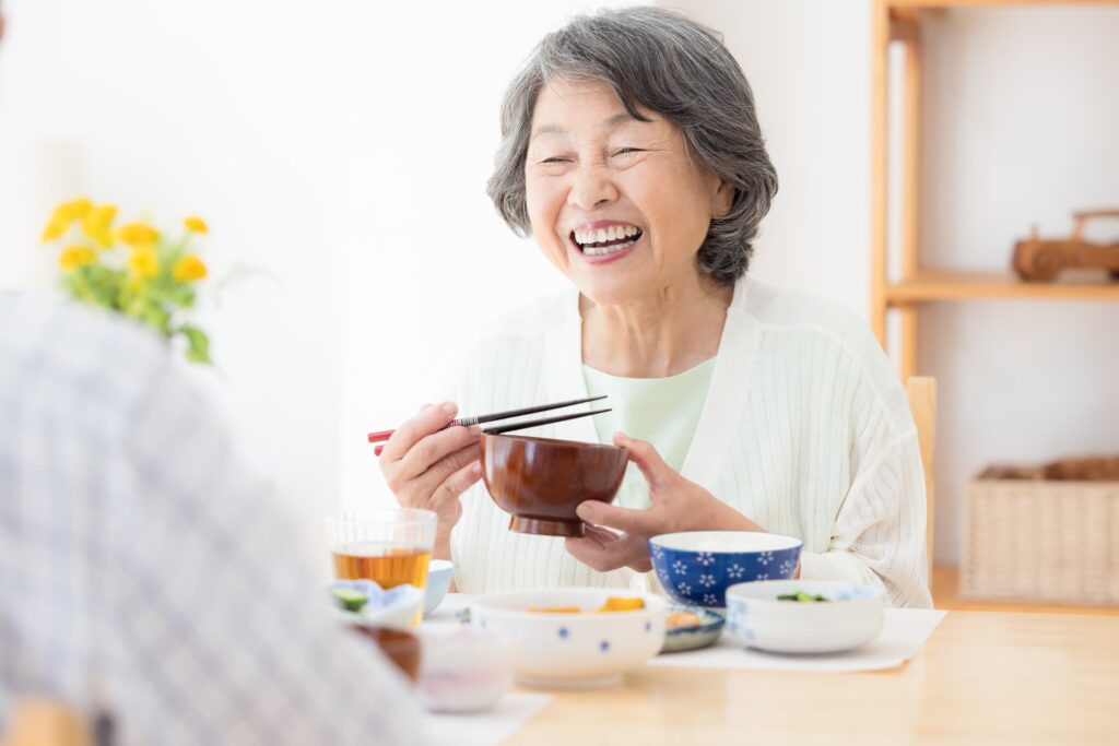 入れ歯の正しいお手入れでお口のトラブルなく食事を楽しむ高齢女性