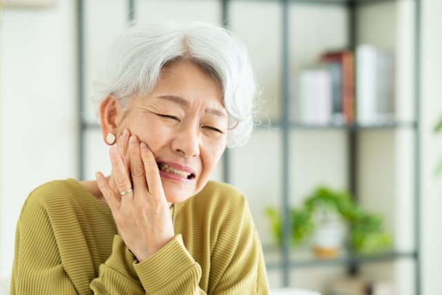 入れ歯が合わず痛みを感じる高齢女性