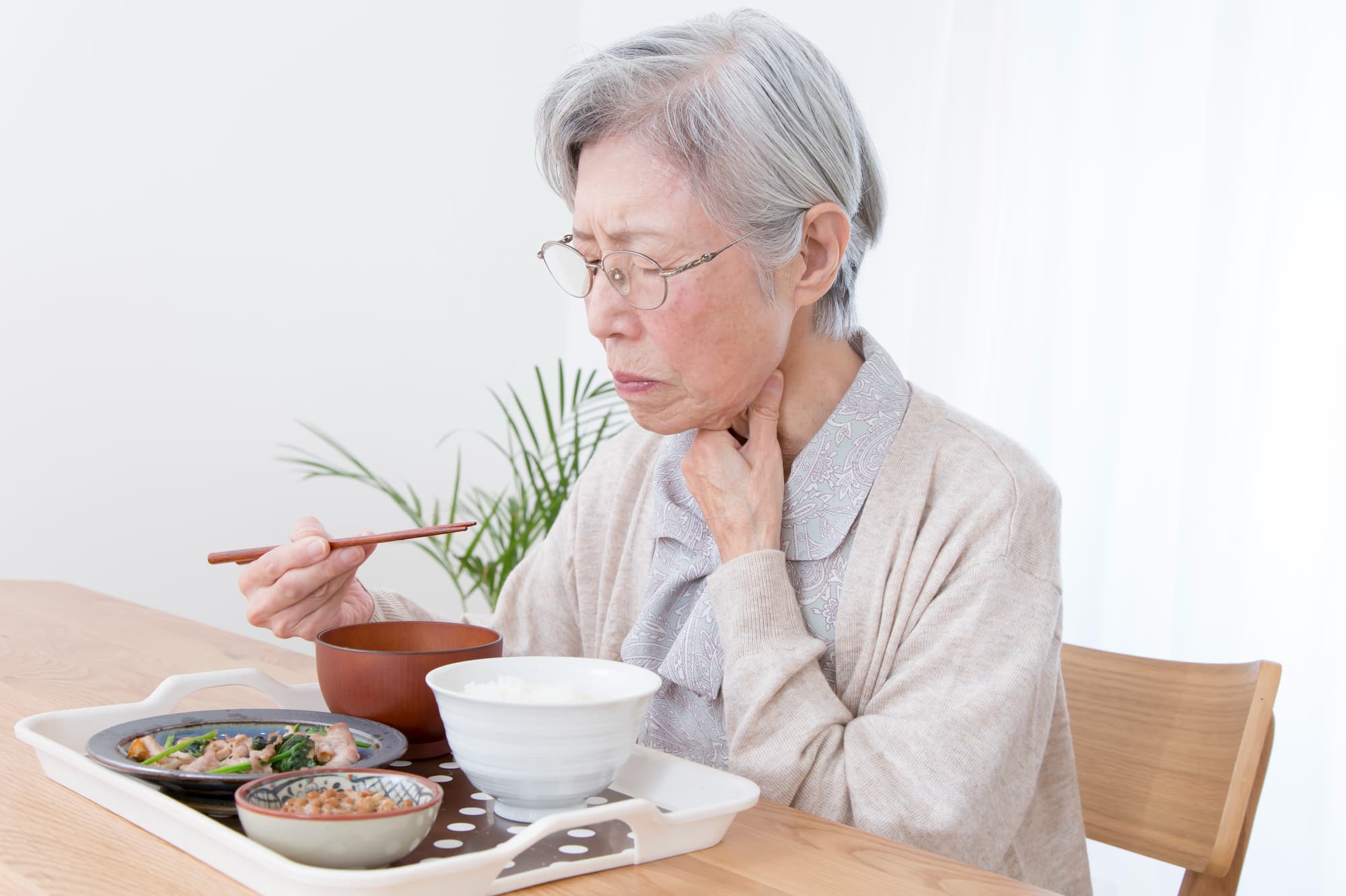 外れやすい入れ歯を使い続けたことで食事がしにくくなった高齢女性