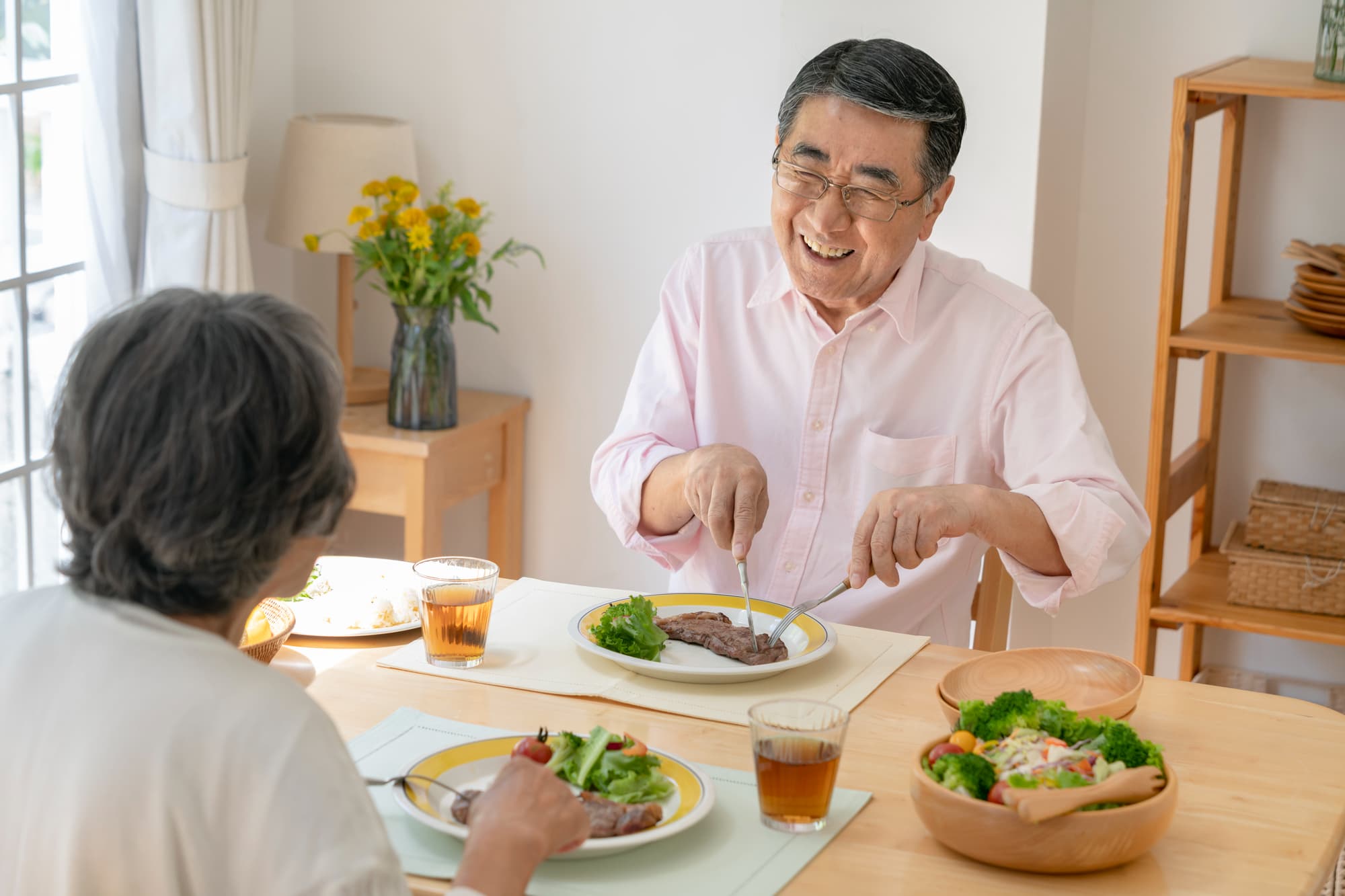 歯のぐらつきを治療して食事を楽しむ男性