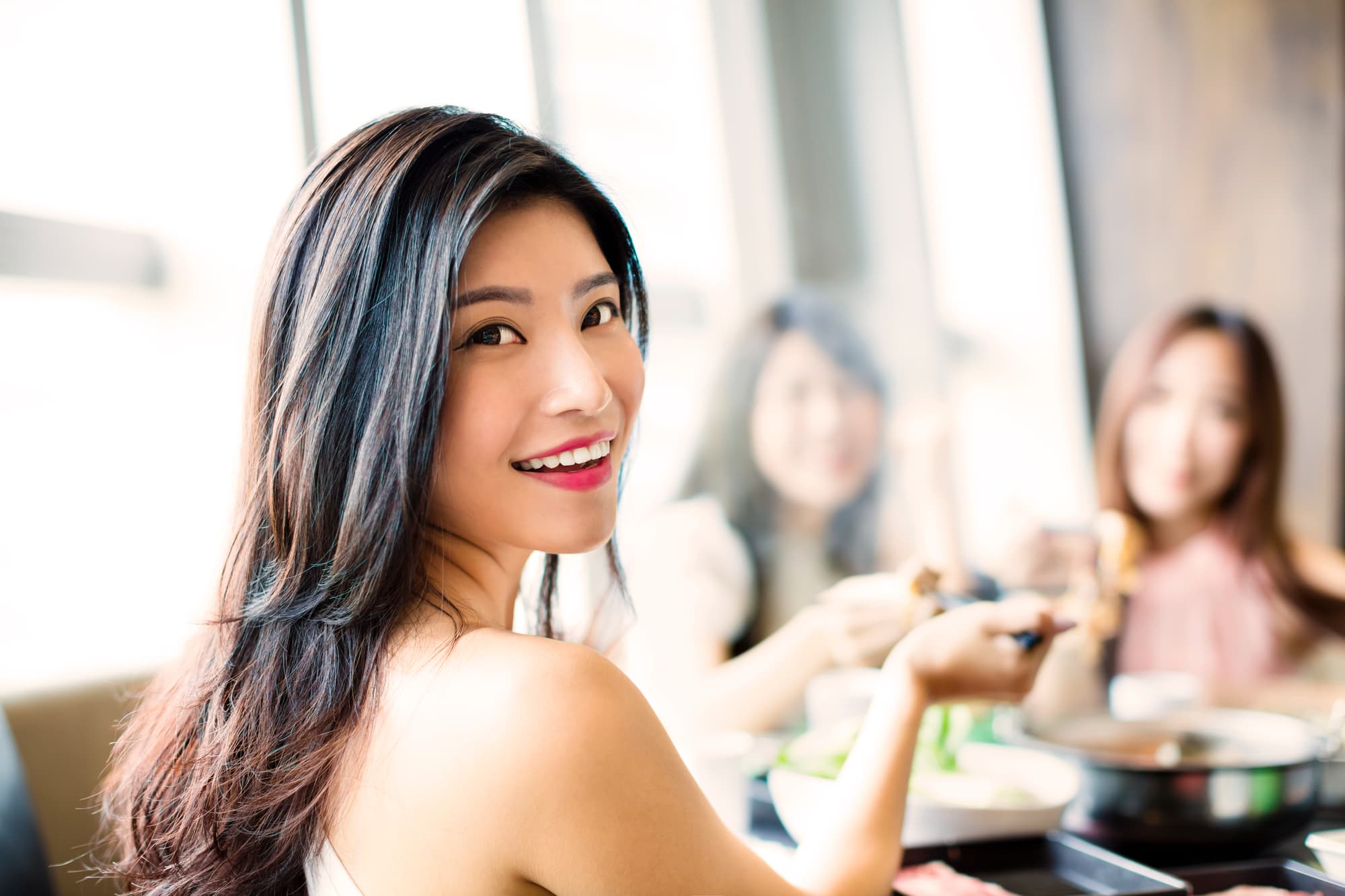 親知らず周辺の腫れが引いて友人との食事を楽しむ女性