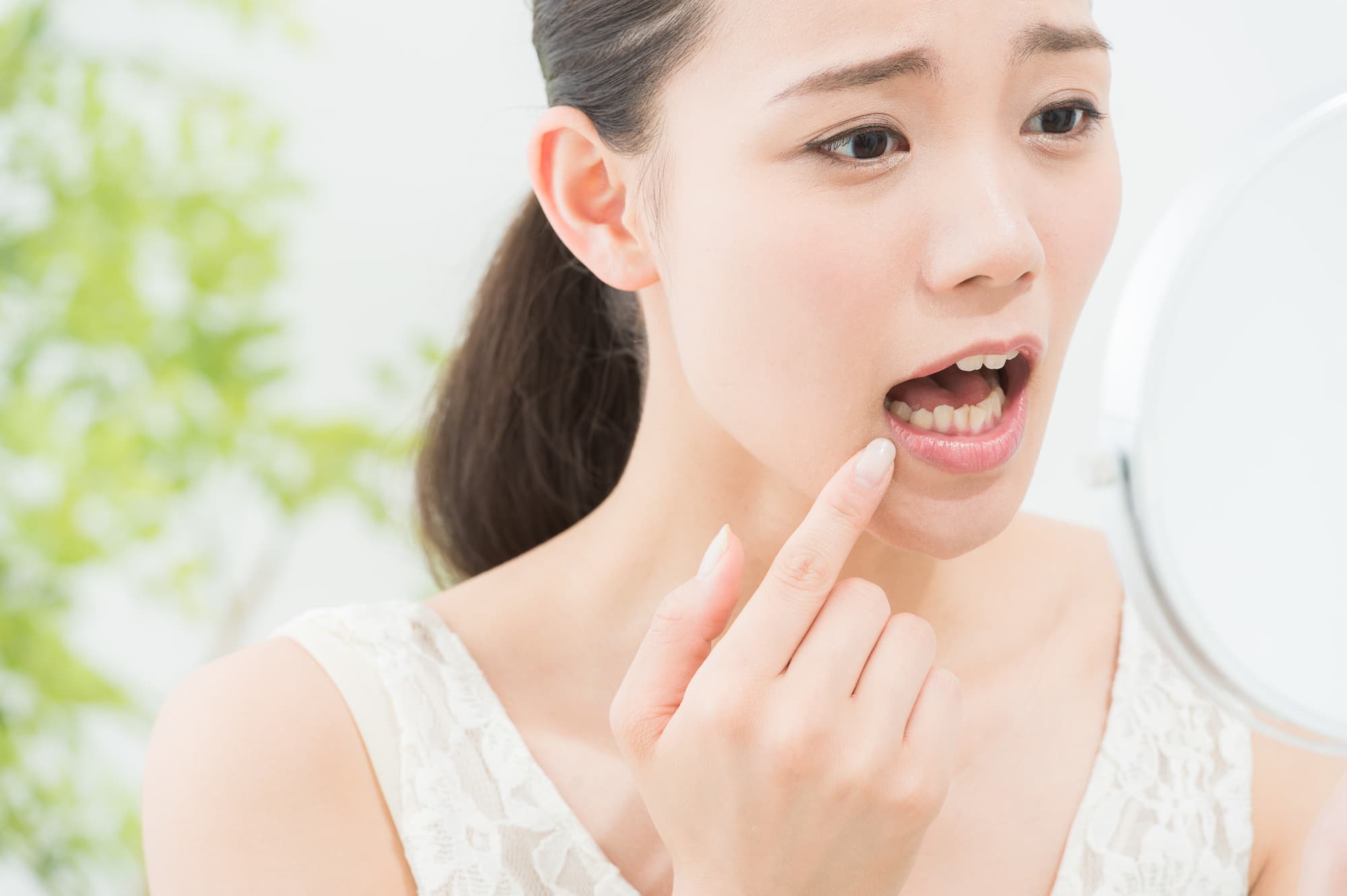 セラミックの歯が取れてショックを受ける女性