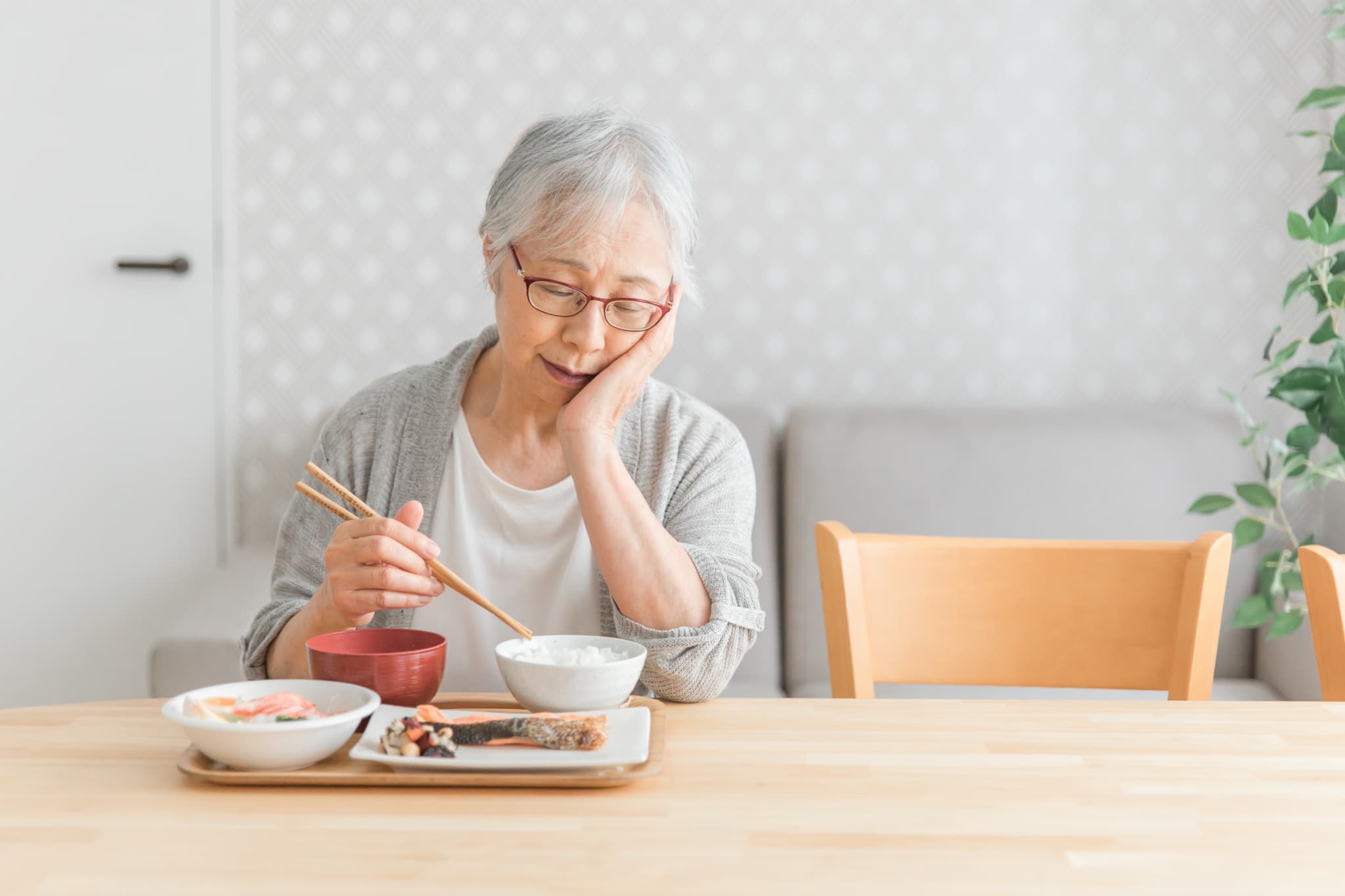 歯がなくなったことで噛む力が弱くなり食事が進まない女性