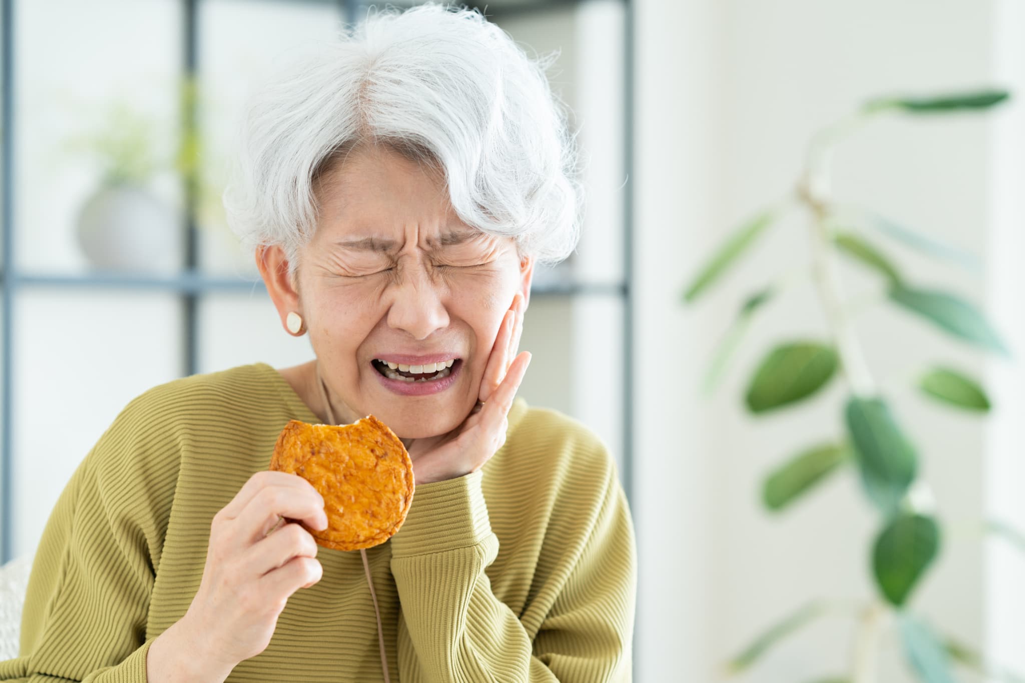 硬いものを無理に噛み顎が痛む女性