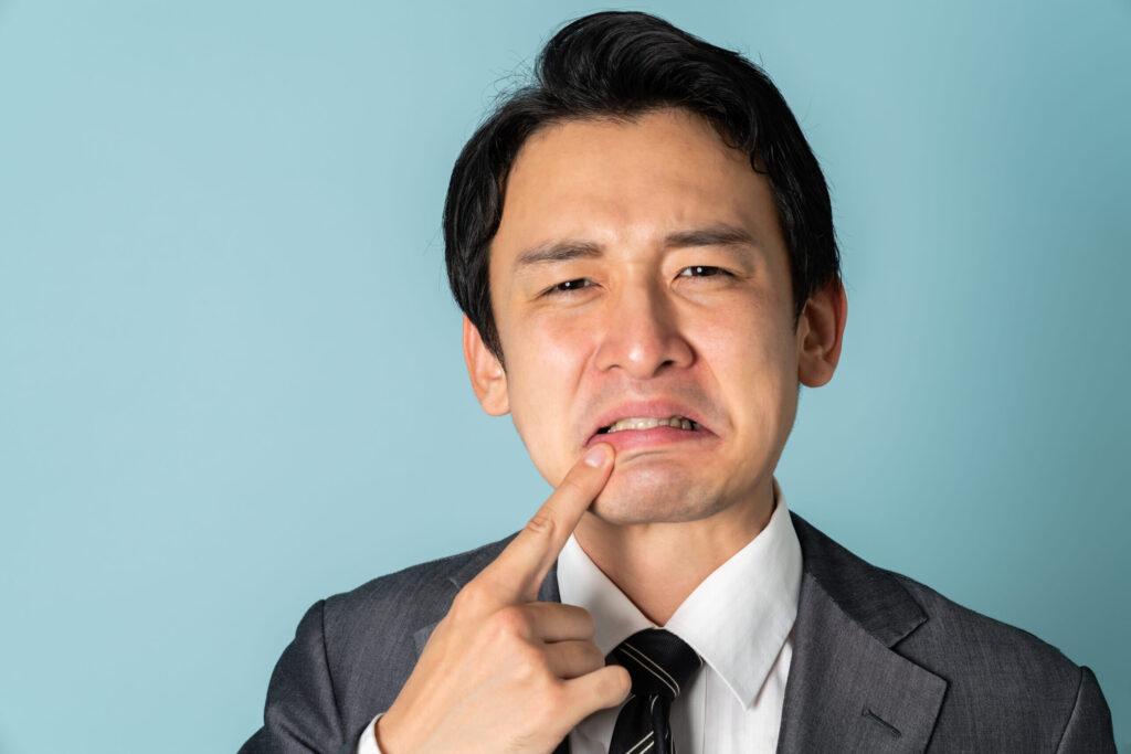 ホワイトニング後に歯がしみている男性